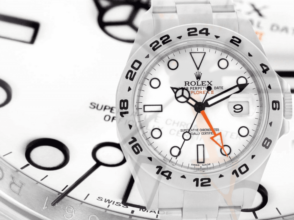 A white Rolex Explorer II with a 24-hour bezel features an orange arrow-tipped hand and is positioned over a background of multiple watch dials, emphasizing its association with adventure and exploration, such as climbing Everest.